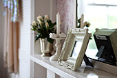 Framed photograph with cut roses and candle on mantlepiece in Brighton home East Sussex England UK
