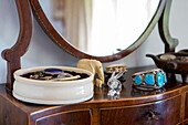 Jewellery and ornaments on dressing table mirror in Devon cottage England UK