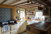 Herd mit blauer Spritzwand in einer Küche mit Balkenrahmen in Amberley, West Sussex, Großbritannien