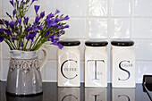 Cut flowers and storage jars in tiled Petworth farmhouse kitchen West Sussex Kent