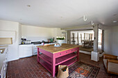 Rosafarbene Kücheninsel in der Petworth-Bauernhausküche mit Backsteinboden in West Sussex Kent