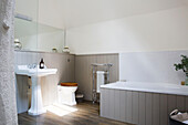 Sunlit pedestal basin in panelled tongue and groove bathroom of Petworth farmhouse West Sussex Kent