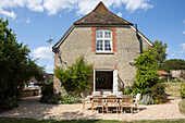 Dining table and chairs on gravel terrace of Petworth farmhouse West Sussex Kent