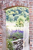 Blick durch ein gewölbtes Backsteintor in den Garten eines Bauernhauses in Petworth, West Sussex, Kent