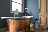 Freestanding copper bath with dark walls in Edwardian West Sussex townhouse England UK