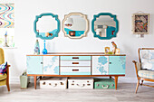 Three mirrors above up-cycled 1970s style sideboard in renovated 1950s coastal beach house West Sussex UK