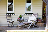 Vintage wooden recliner and chair on patio exterior of West Wittering beach house West Sussex England