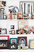 Photographs and ornaments on white shelves in London family home,  England,  UK