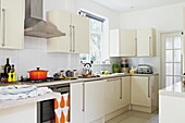 Cream fitted kitchen in London family home  England  UK