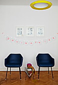 Pair of black leather chairs and home-made bunting in London family home  England  UK