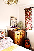 Acoustic guitar and wooden chest of drawers in bedroom of  Birmingham home  England  UK
