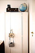Schwarzer Koffer und Kamera mit Globus auf dem Kleiderschrank in einem Haus in Birmingham, England UK