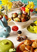Hand-painted Easter eggs and daffodils on kitchen table in London home   England   UK