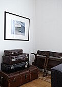 Vintage suitcases and old wooden cinema seats in contemporary London home   England   UK