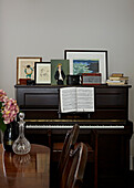 Polished wood dining table and piano in contemporary London home   England   UK