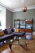 Corner sofa with glass-topped coffee table and side unit in London family home  England  UK