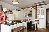 Old red coffee grinder in open plan kitchen of UK farmhouse
