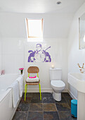 Superman cartoon below skylight with lime green metal framed chair in white bathroom of London home,  England,  UK