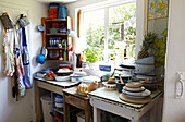 Kitchenware and herbs at sunlit window of Brabourne farmhouse,  Kent,  UK