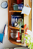 Vintage whisk and cake tin with kitchenware on wall mounted shelf unit in Brabourne farmhouse,  Kent,  UK