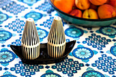 Salt and pepper pots on retro style tablecloth in Brabourne farmhouse kitchen,  Kent,  UK