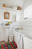 White bathroom with wooden mirror above pedestal basin in Brabourne farmhouse,  Kent,  UK