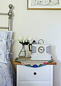 Coffee machine and cut roses on bedside table in Brabourne farmhouse bedroom,  Kent,  UK