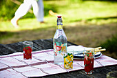 Vintage bottle and plates on picnic table in Brabourne garden,  Kent,  UK