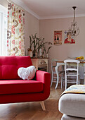 Bright red sofa in open plan dining and living room of Bolton home,  Greater Manchester,  England,  UK