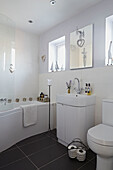 White bathroom with black tiled floor in Bolton home,  Greater Manchester,  England,  UK