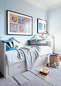 Daybed below framed poster saying 'Change' in  London townhouse  England  UK