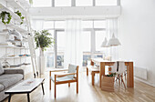Esstisch und Regale mit Leiter im offenen Wohnzimmer einer Londoner Wohnung UK