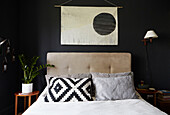 Black and white pillow under Oriental wall hanging in Sheffield bedroom  Yorkshire  UK