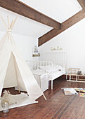 Single bed with laundry basket and teepee in attic bedroom of West Yorkshire home  UK