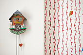 Cuckoo clock with red patterned wallpaper and robin in Berwick Upon Tweed home  Northumberland  UK