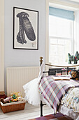 Tartan blanket on metal framed bed with framed dog cartoon in Berwick Upon Tweed home  Northumberland  UK