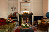 Sofa und Sessel mit großem Spiegel über dem viktorianischen Kamin im Wohnzimmer in Rochester Kent UK