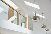Silberne Pendelleuchten und Oberlichter mit Glaszwischengeschoss in einem Neubau in Devon UK