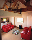Split level home office conversion with bright red leather sofa