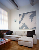 Modern cream upholstered corner suite with large abstract painting