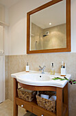 White ceramic basin in wash stand below mirror in New Malden home, Surrey, England, UK
