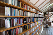 Umfangreiche Büchersammlungen in Regalen in der umgebauten Wassermühle