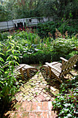 Stühle im Freien auf einer gemauerten Terrasse im Garten