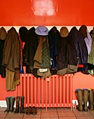 Red Hallway with coats and hats and boots with radiator