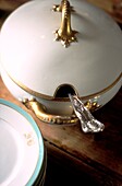 Close up of French gold rimmed serving dish with silver serving spoon