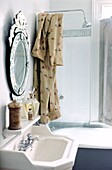 Detail des Badezimmers mit Handwaschbecken und Dusche über der Roll-Top-Badewanne