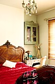 Schlafzimmer mit Doppelbett aus Nussbaumholz im Louis-XVI-Stil mit roter Satin-Bettdecke