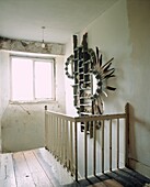 Totemic mirror wall piece out of driftwood in stairwell