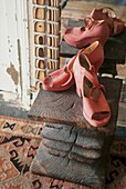 Stilleben mit rosa Schuhen auf handgefertigtem Holzschemel