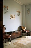Marble flagstone hall with antique furniture and wall lights